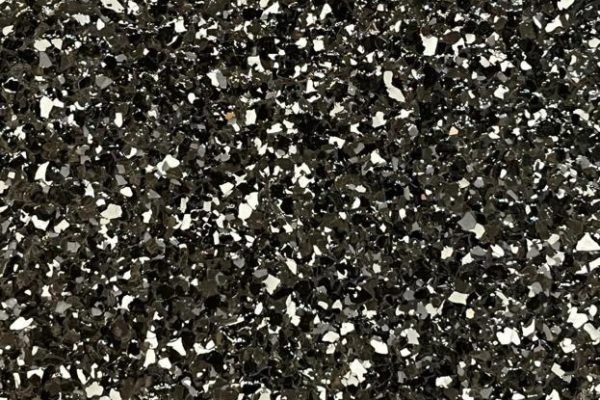 Cafe Black Epoxy Flooring Close-up of Cafe Black epoxy flooring featuring a textured black finish with white and grey decorative flakes.