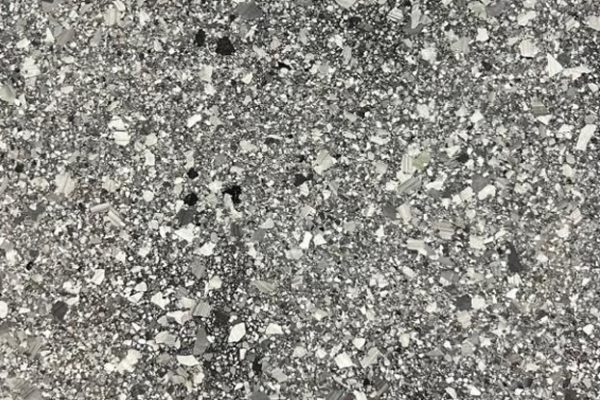 Basalt Fleck Epoxy Flooring Close-up of basalt-colored epoxy flooring with a multi-tonal grey and black decorative flake finish.