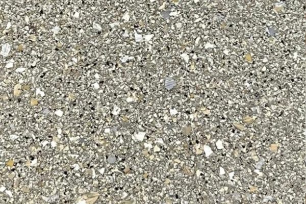 Jasper Flake Epoxy Flooring Close-up of Jasper color epoxy floor coating with mixed grey, white, and black flakes.